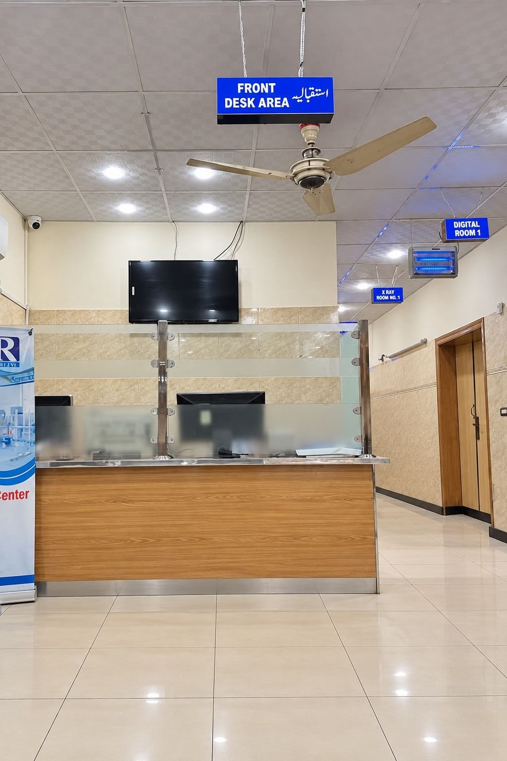 The front desk with bilingual signs for the reception, Digital Room 1 and X-ray Room 1